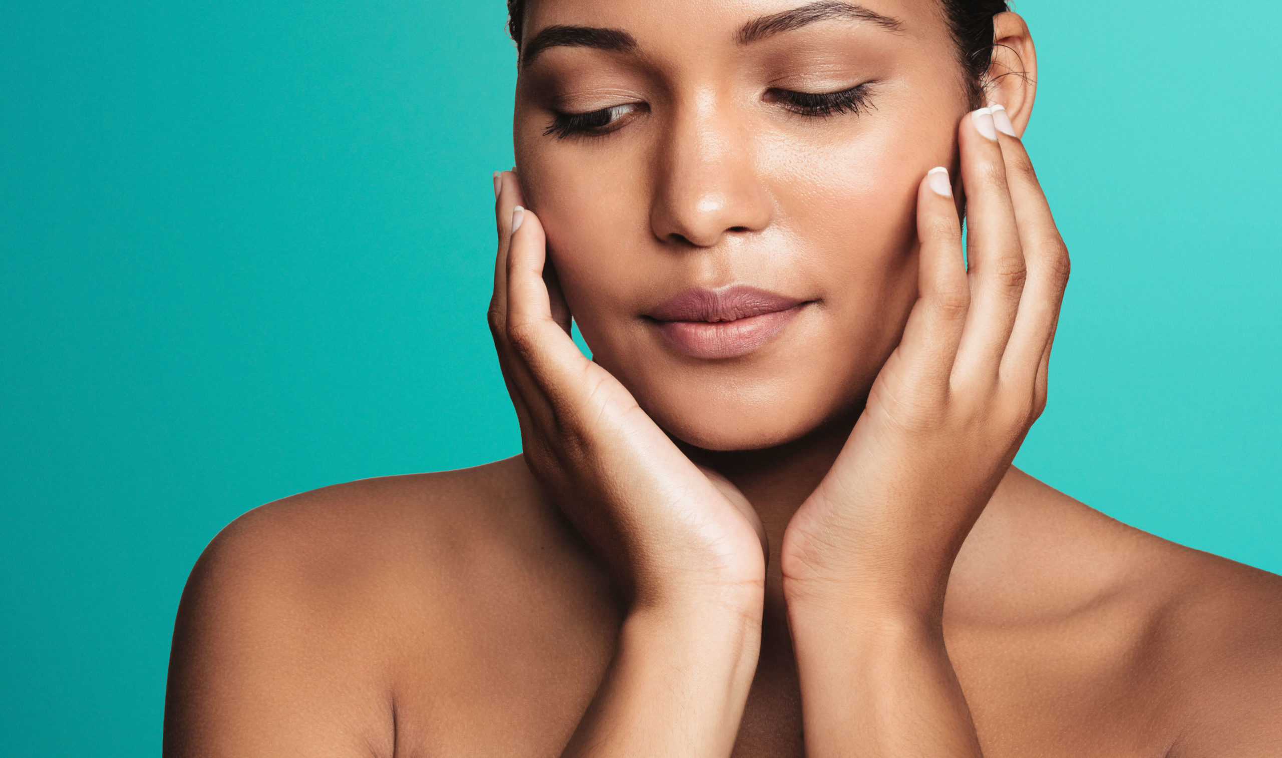 Sofwave ultrasound skin lifting Dublin - close-up of a woman with eyes closed framing Close-up of a woman with eyes closed framing her face with both hands against for Sofwave ultrasound skin lifting in Dublin